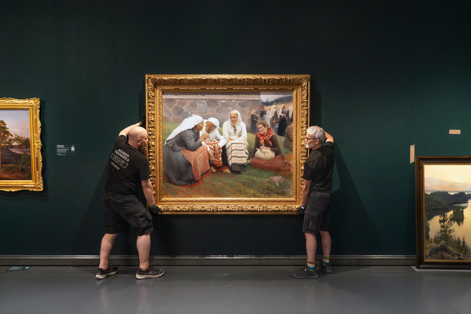 Museomestarit nostavat Edelefeltin suurta teosta seinän edessä Ateneumin näyttelysalissa kiinnittääkseen sen seinälle.
